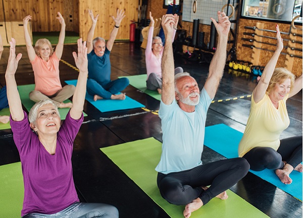 group of seniors doing stretching in yoga studio