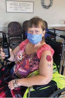 Springfield resident sitting in chair showing off her new tattoo and rootbeer